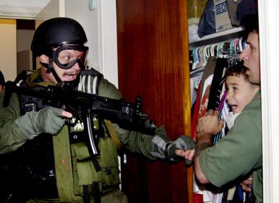 U.S. Federal INS Agent with weapon aimed towards six year old Elian Gonzalez